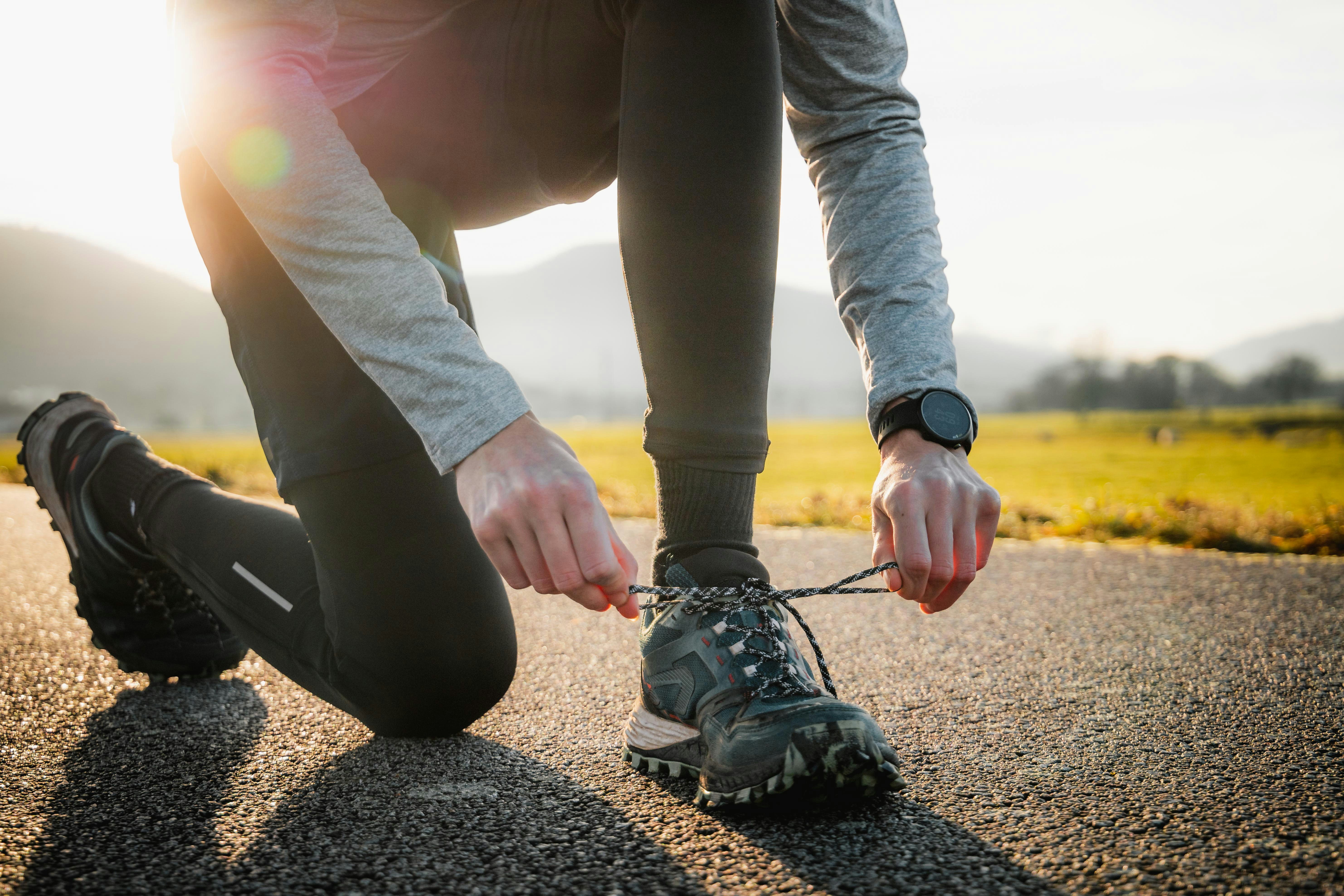 Runner tying an athletic shoe before activity